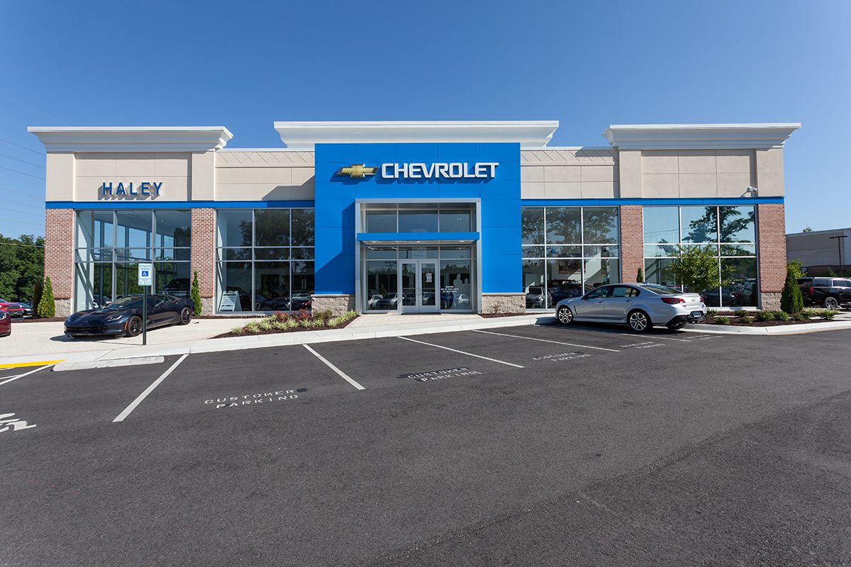 1 Exterior of a modern Chevrolet car dealership with parked cars and clear skies