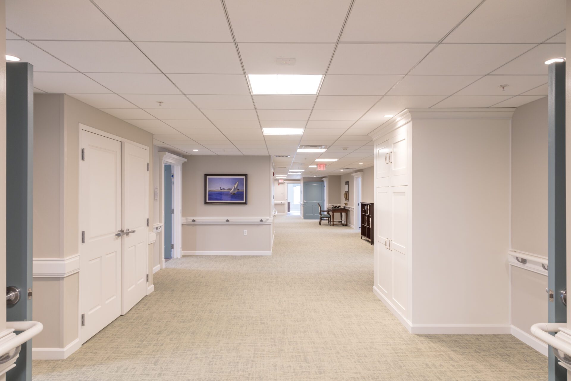 8 Bright, modern office hallway with doors and framed artwork on walls